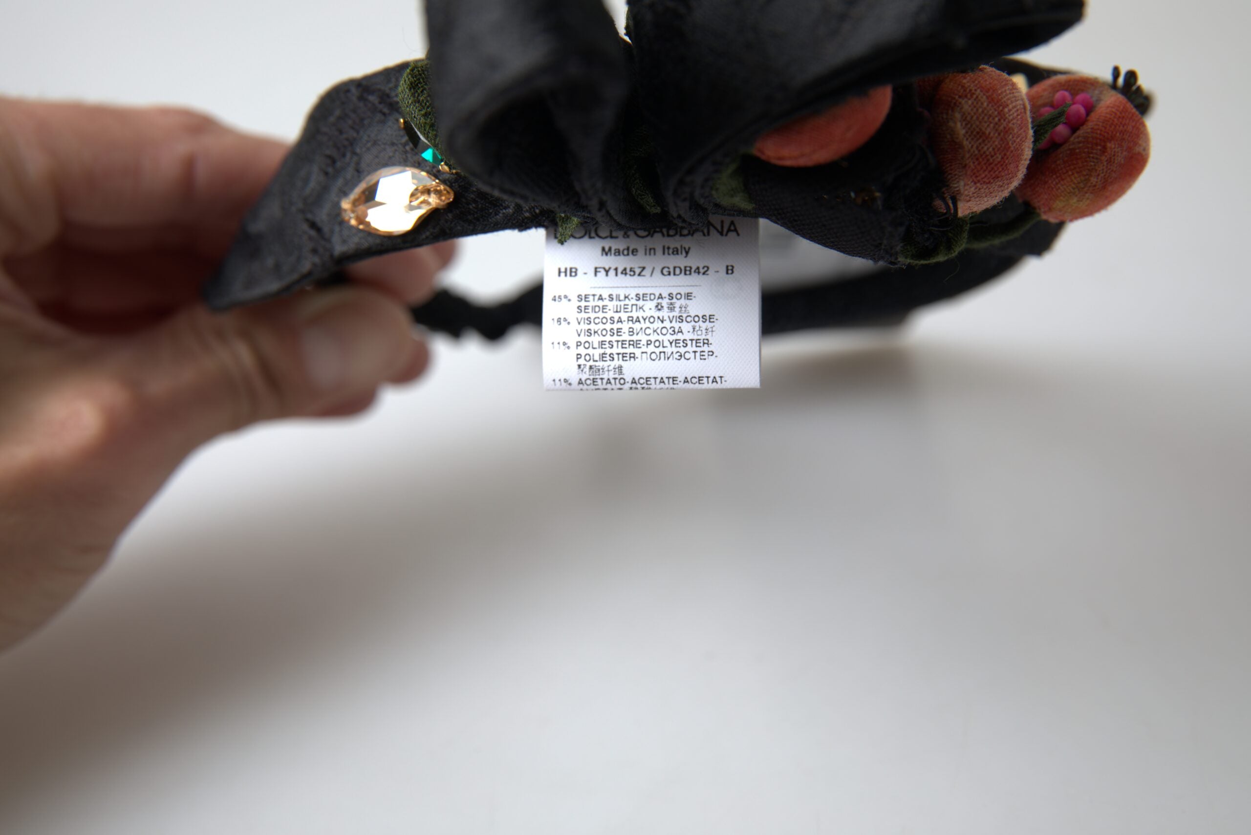 عصابة رأس من دولتشي آند غابانا باللون الأسود مع تاج كريستالي متعدد الألوان على شكل فاكهة التين